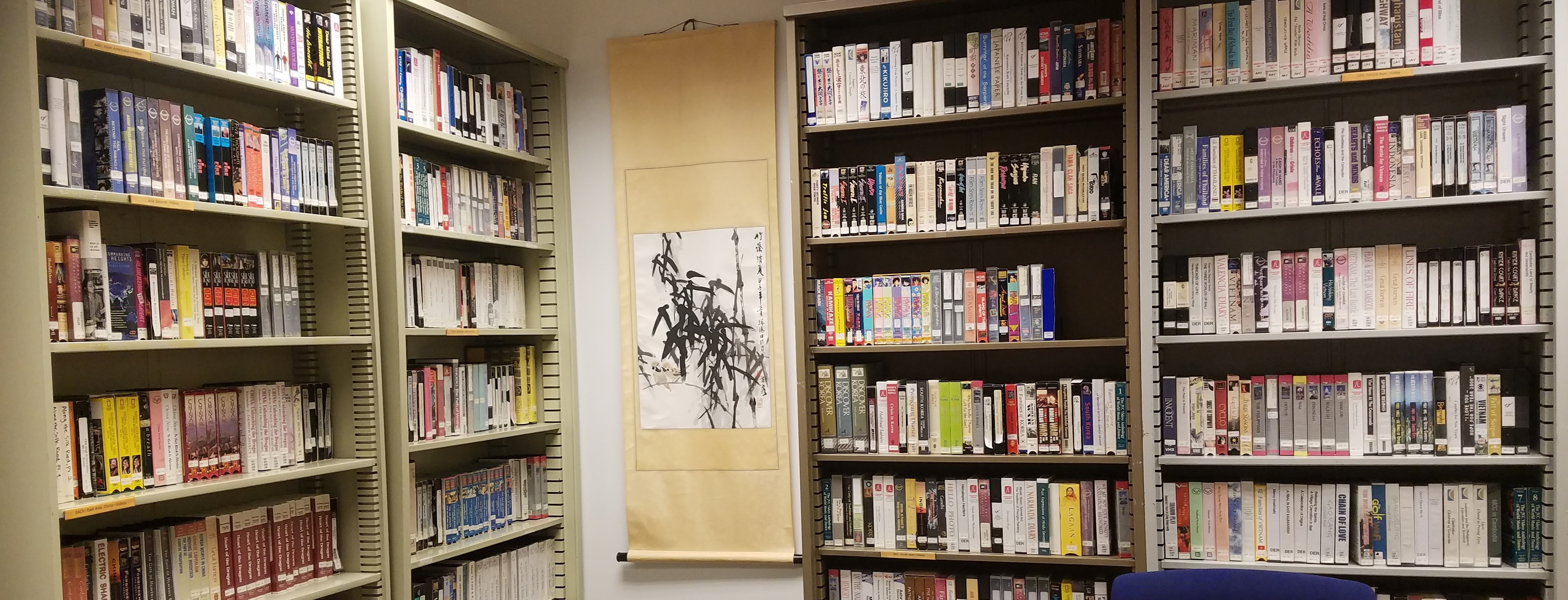 AEMS Library bookshelves with a hanging scroll on the wall.