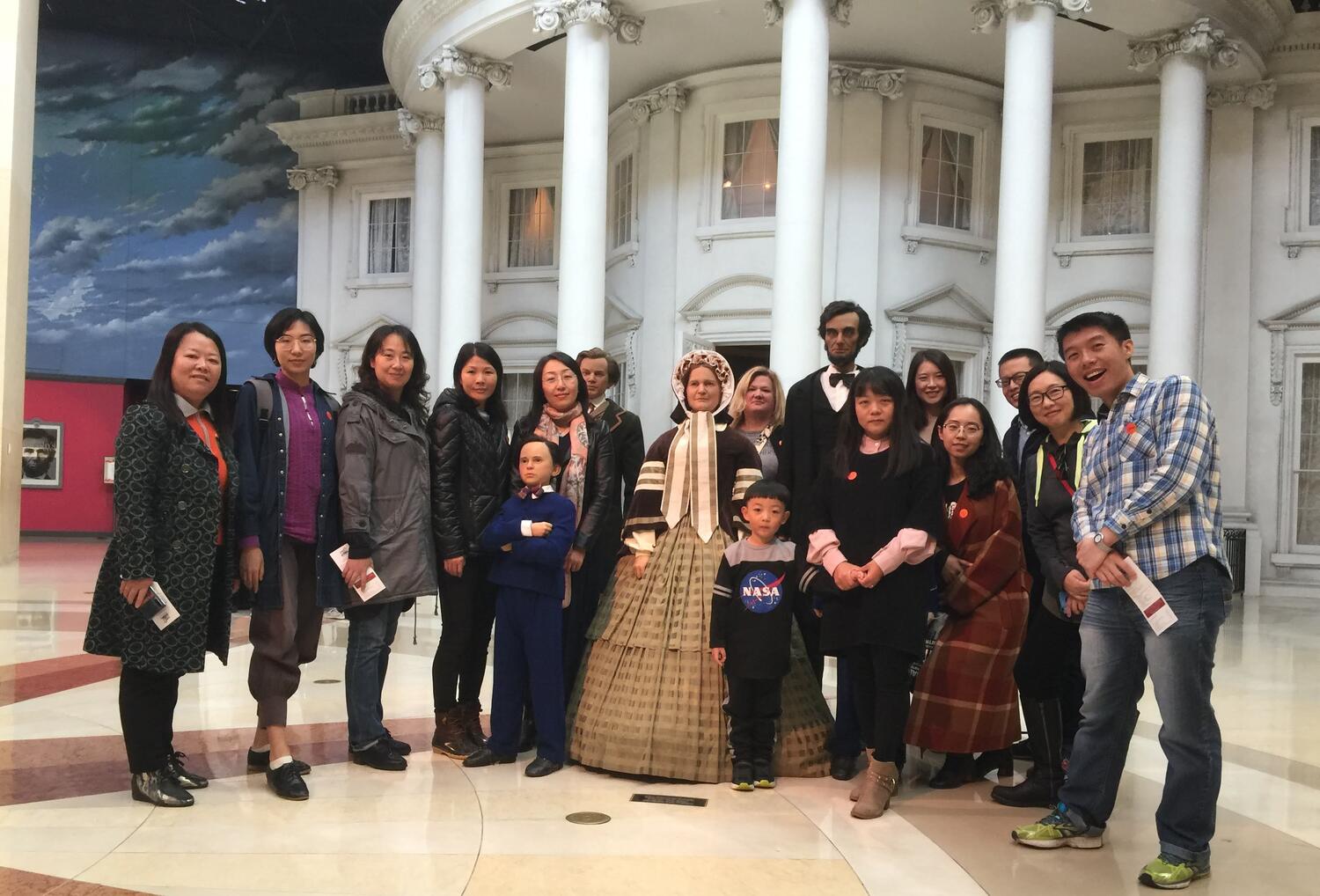 Visiting Asian Scholars and CEAPS Staff posing near two statues in the Abraham Lincoln Presidential Library and Museum